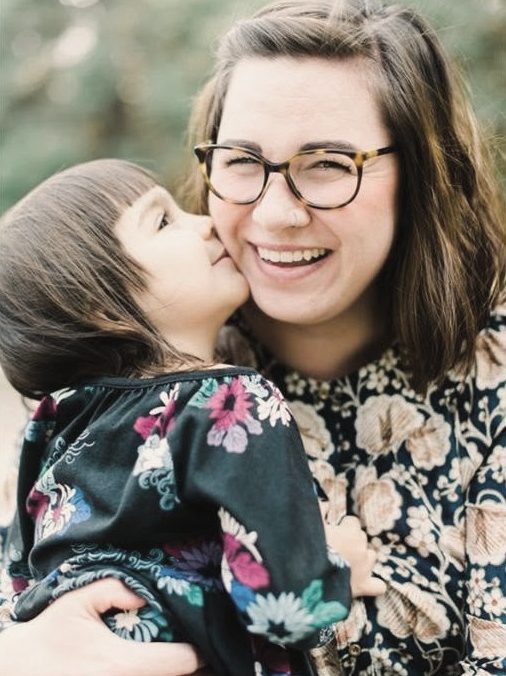 Little girl kissing her mom on the cheek
